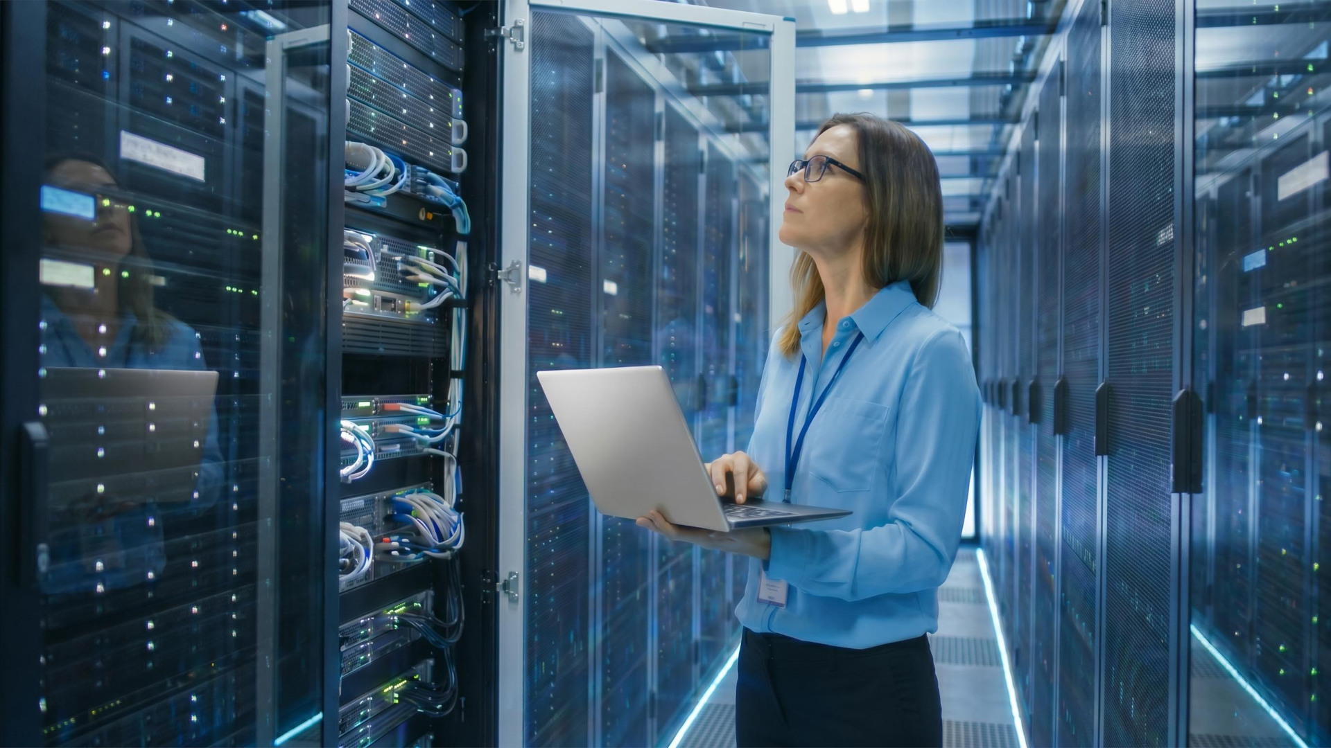 IT-Technikerin arbeitet mit einem Laptop im Serverraum.