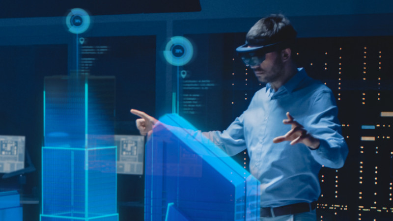 Ingenieur mit VR-Brille steuert ein digitales Modell smarter Gebäude.