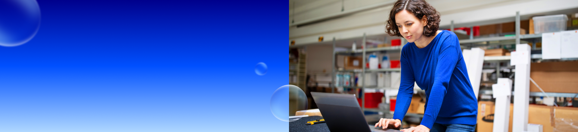 Abbildung: Eine Frau steht an einem Tisch und schaut auf ihren Laptop