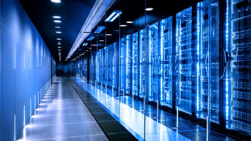 Moderner Rechenzentrumsgang mit blau beleuchteten Serverracks bei o2 Business Data Center Housing