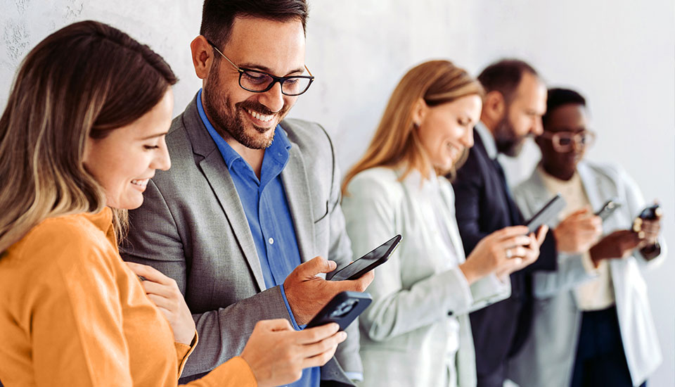 Gruppe von Menschen hält Smartphones in den Händen – Symbolbild für kompatible Geräte mit o2 Business Safety Net.